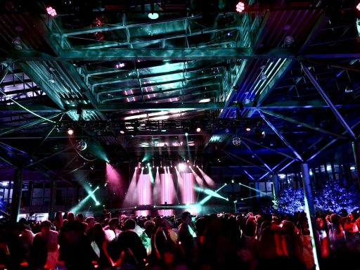 Bunte Lichtshow in einer gefüllten Indoor-Veranstaltungsstätte.